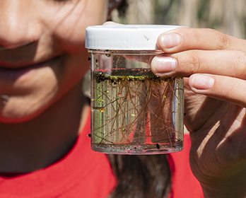 A Knightsen Elementary School student smiling while holding a soil sample.