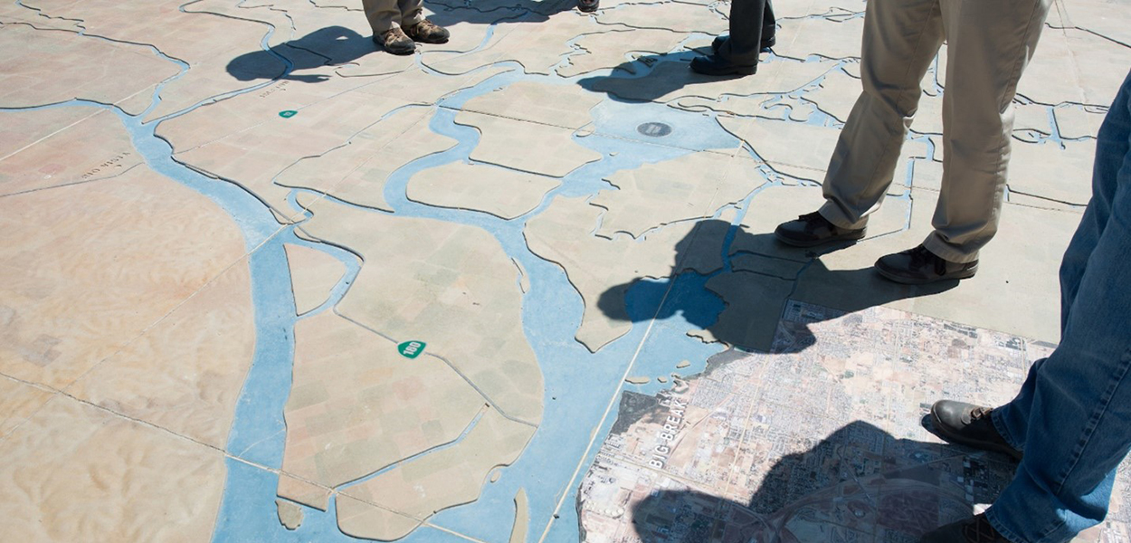 People standing on a large map of the Sacramento-San Joaquin Delta watershed at Big Break Regional Shoreline.