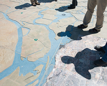 People standing on a large map of the Sacramento-San Joaquin Delta watershed at Big Break Regional Shoreline.