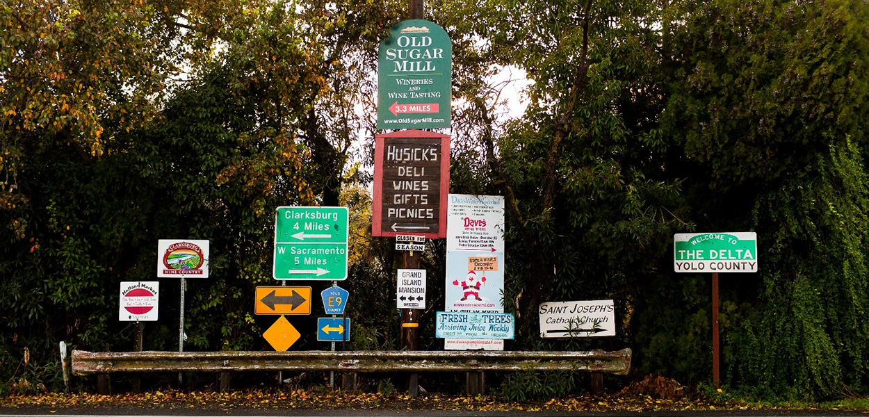 A collection of road and business signs in the Delta, Yolo County.