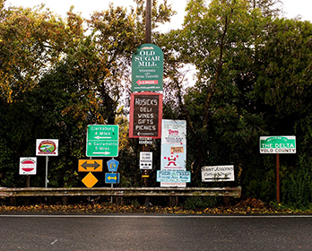 A collection of road and business signs in the Delta, Yolo County.