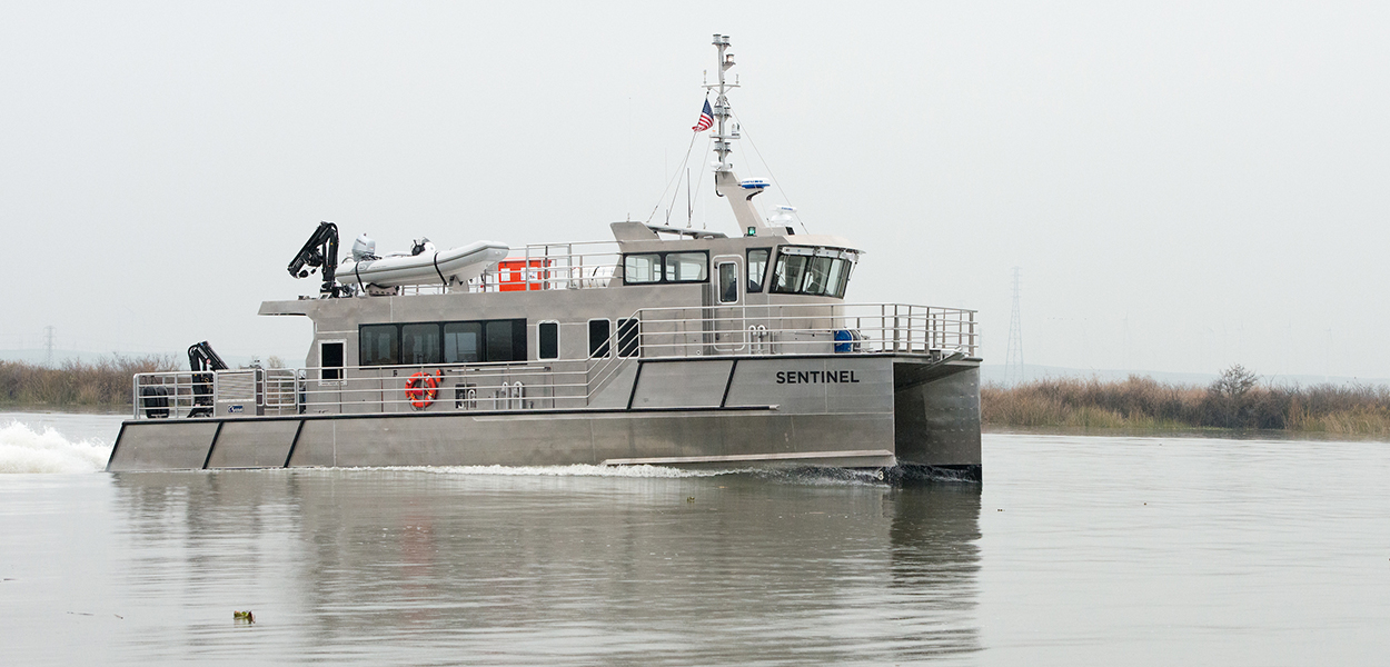 A Delta Interagency Ecological Program research vessel, the Sentinel, sails on the San Joaquin River near the Antioch bridge.