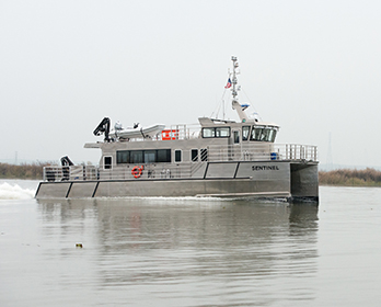 A Delta Interagency Ecological Program research vessel, the Sentinel, sails on the San Joaquin River near the Antioch bridge.