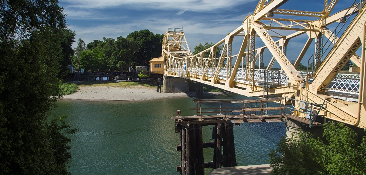 A yellow steel bridge spanning the Sacramento River near Isleton, California.